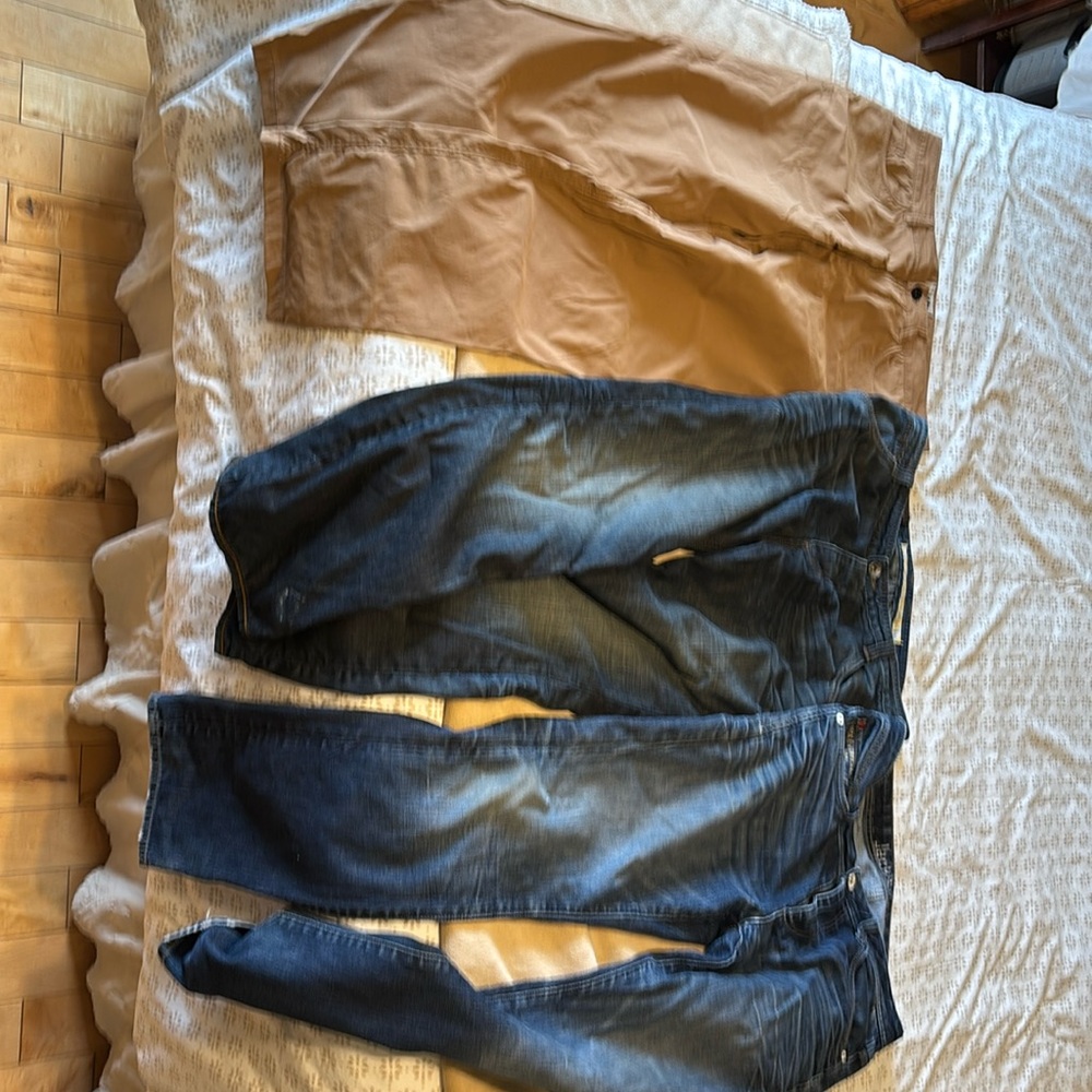 Three pairs of pants, two denim one North Face